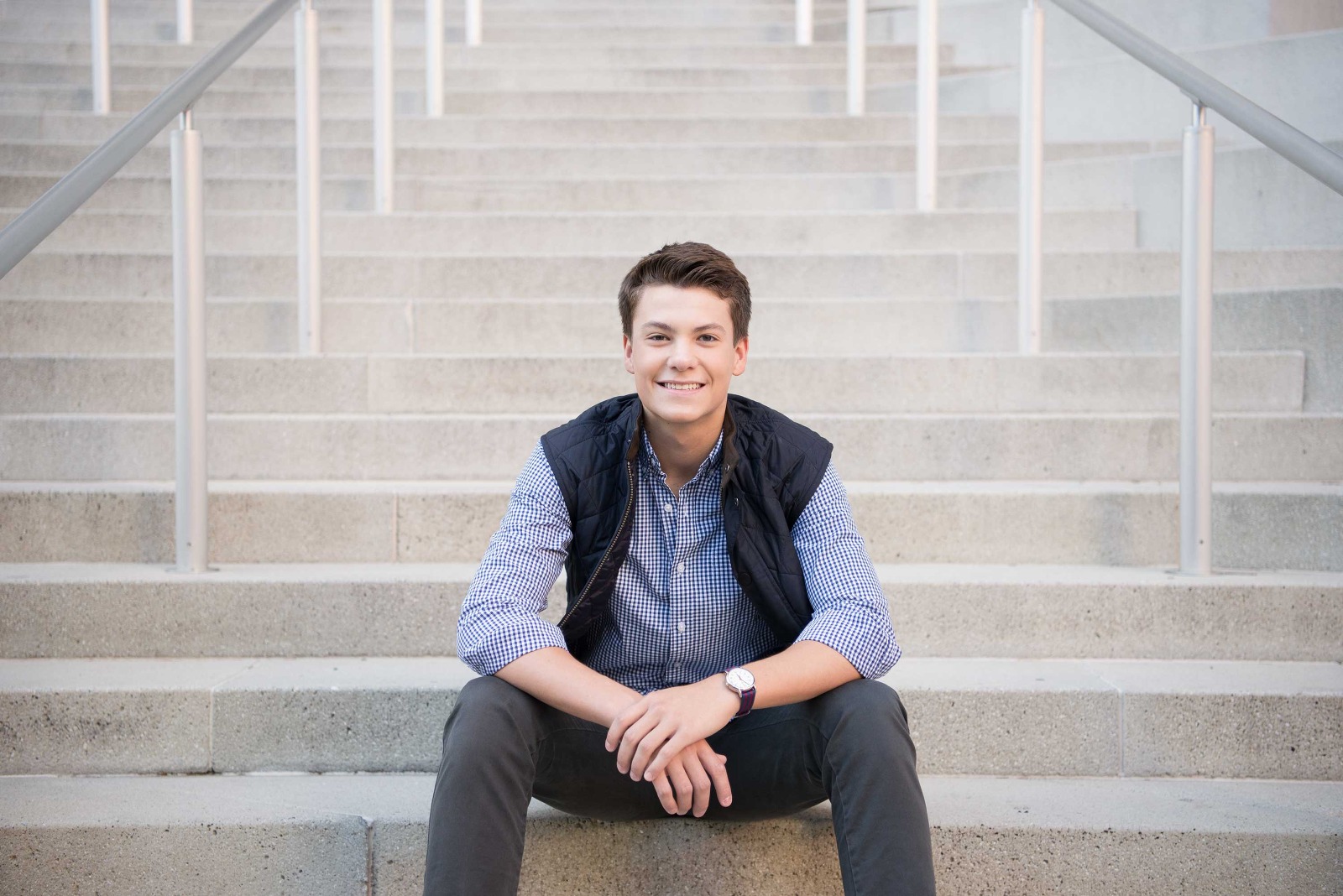 young man sitting on stairs for senior portrait