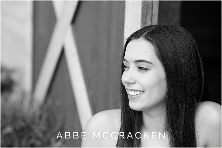 Black and white high school senior portrait at barn in Marvin, NC