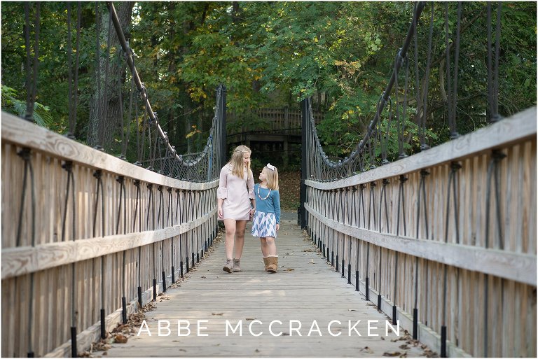 Lifestyle image of sisters walking across a bridge