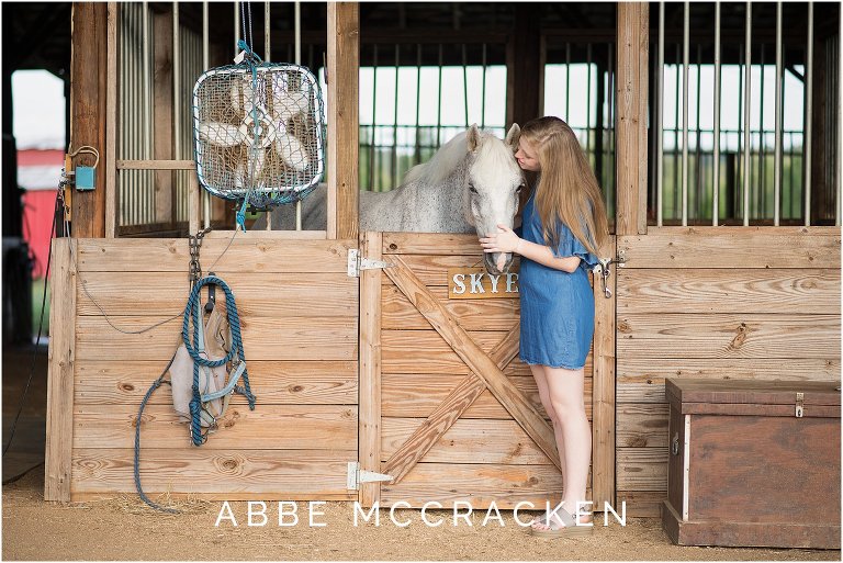 Portrait of a senior girl and her horse, taken in the stables at her family farm south of Charlotte, NC