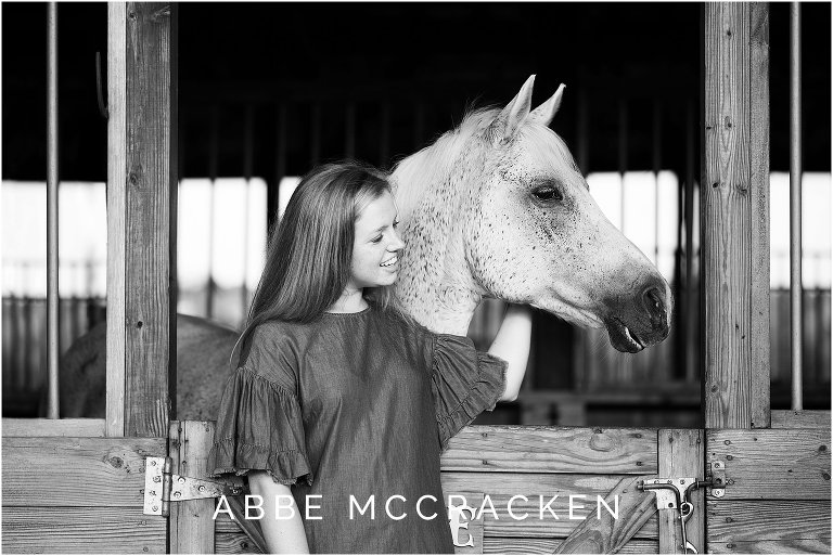 Black and white portrait of a high school senior with her horse