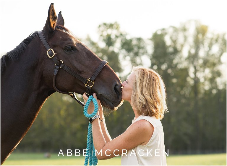 Candid portrait of owner kissing her horse at Old Frankfort Farm and Stables in Waxhaw, NC