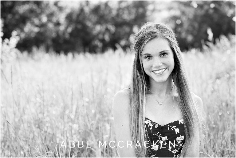 Black and white senior portrait in wheat fields, tall grasses