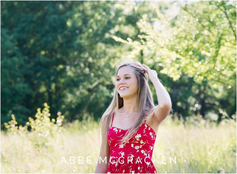 Candid portrait of a high school senior laughing while standing in wheat fields
