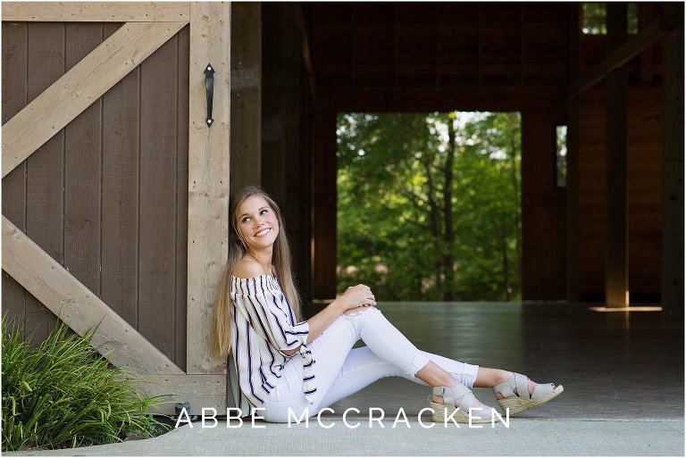 Senior portrait leaning against a barn at Marvin Efird Park in Marvin, NC