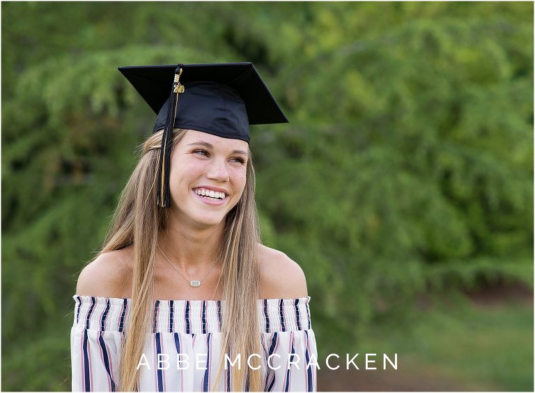 Candid senior portrait of girl laughing wearing her graduation cap