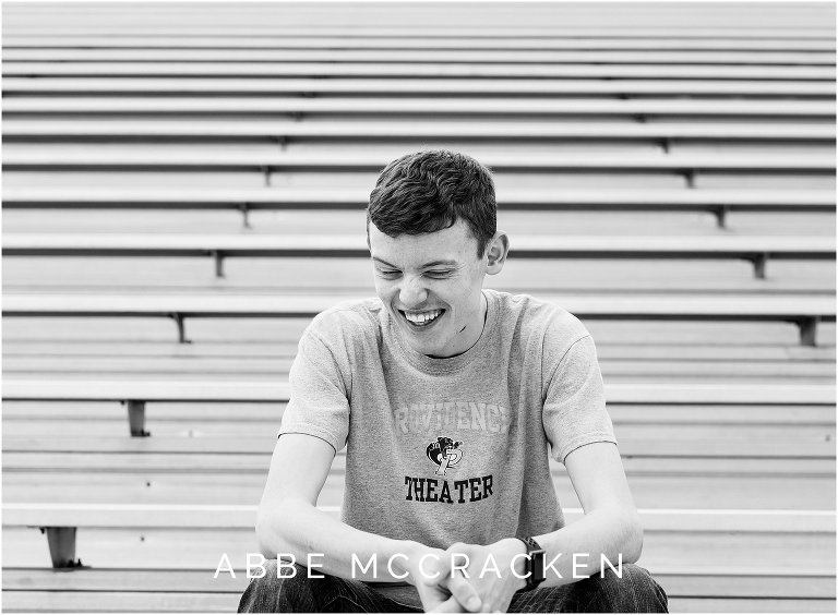 Candid image of a high school senior laughing. Photographed in the football stadium at Providence High School in Charlotte NC