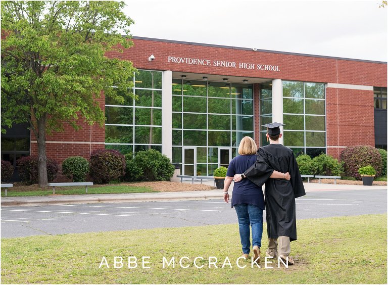 Mother and graduating senior son walking towards his high school, Providence High School in south Charlotte