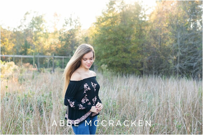 Senior portrait of a girl looking down, hair blowing in the win