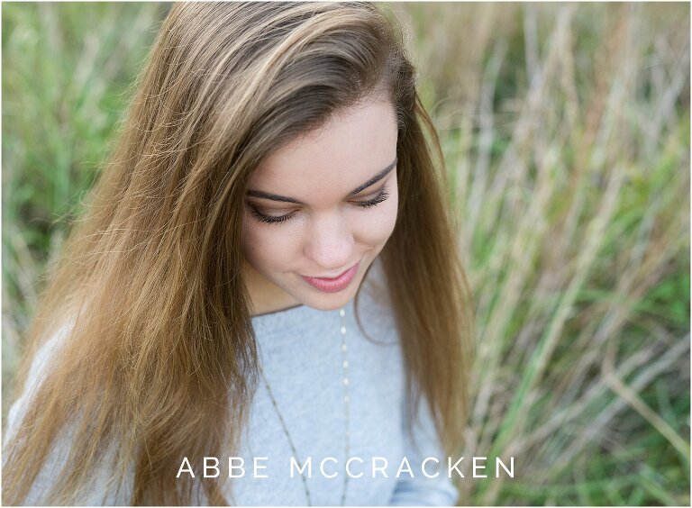 Close up portrait of a high school senior, gaze cast downwards, focus on eyelashes