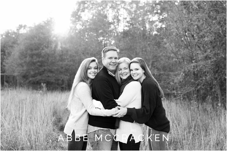 black and white portrait of a family with a high school senior