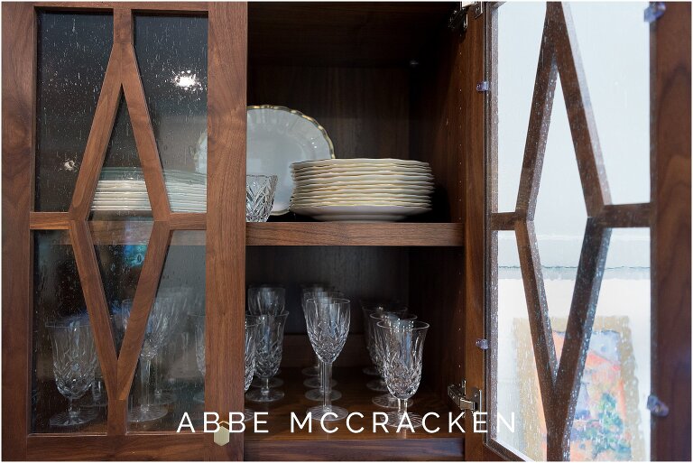 Details of a gorgeous dark wood china cabinet in stunning white remodeled kitchen