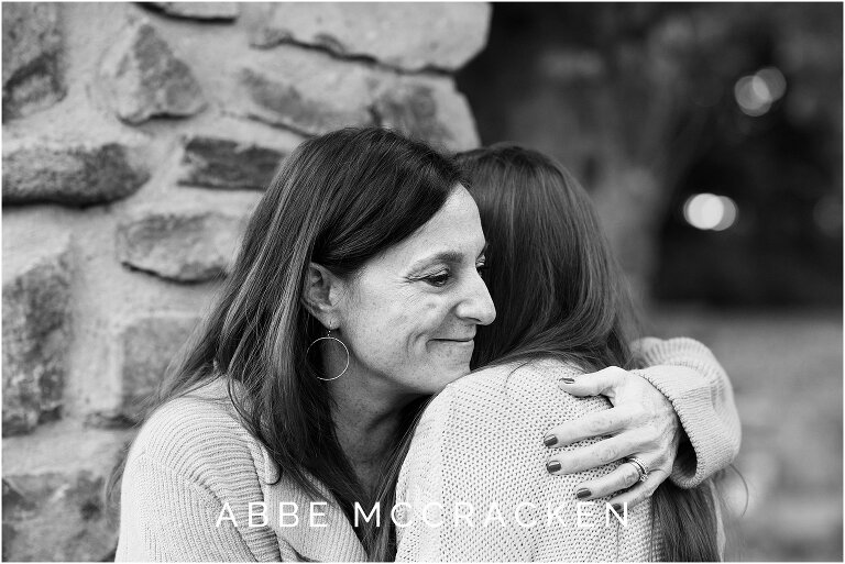 black and white emotional image of mother hugging her teenage daughter