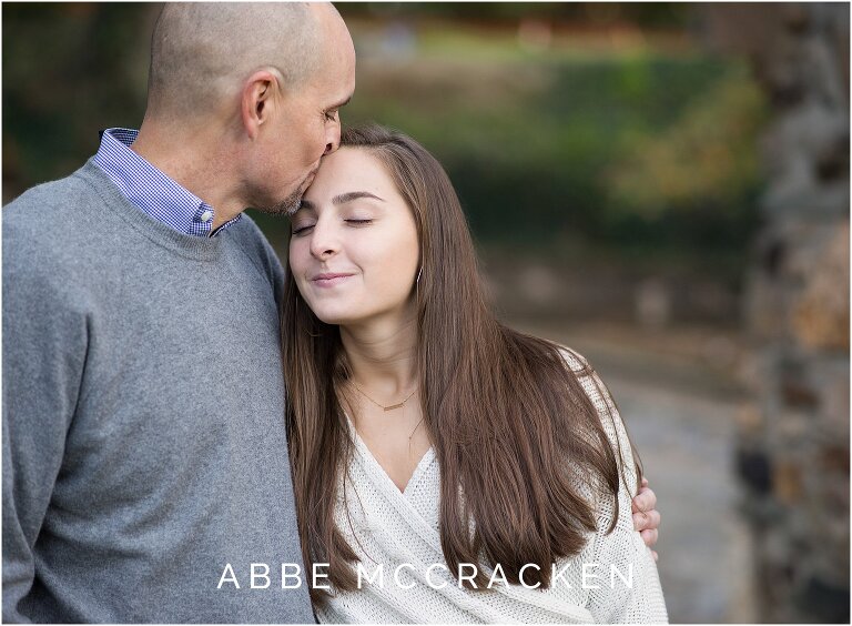 Tender kiss between a father and his high school senior daughter