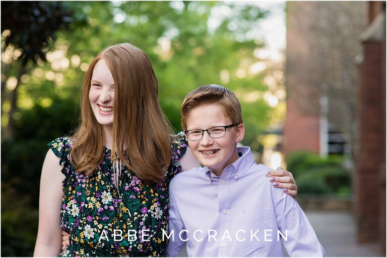 Red headed siblings laughing at each other during a spring family portrait session