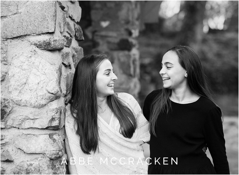 teenage sisters laughing at each other during a fall senior portrait session