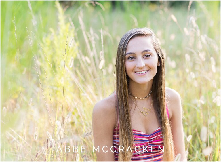 Summer portrait of a high school senior sitting amongst the tall wheat grasses near Charlotte, NC