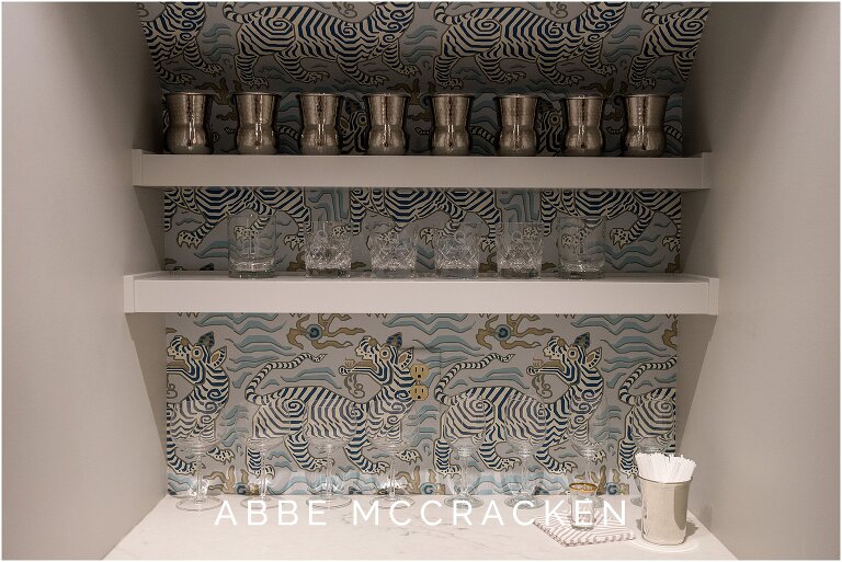 Bold blue and grey wallpaper in former closet turned bar area