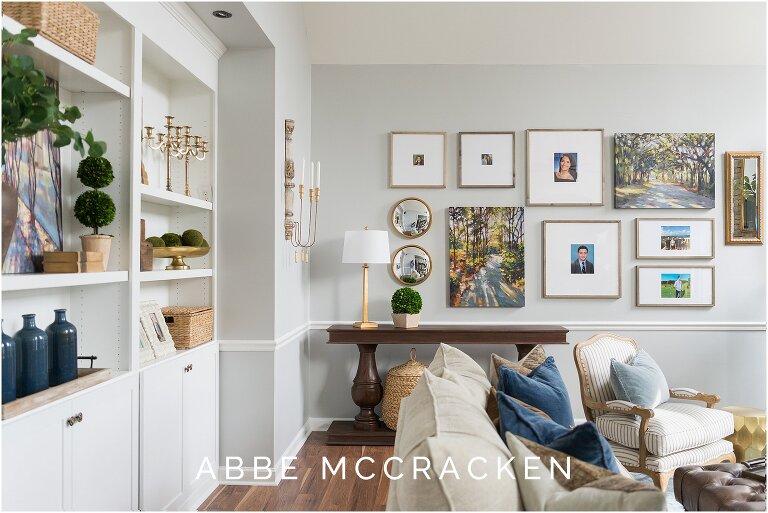 Interior design photography showcasing new built in bookcases and sofa leading to photo wall of family pictures