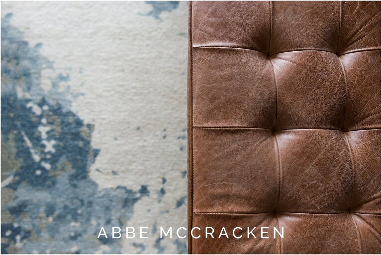 brown leather ottoman paired with blue and cream rug