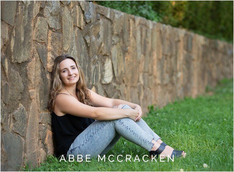 Senior leaning against stone wall in Charlotte's Independence Park