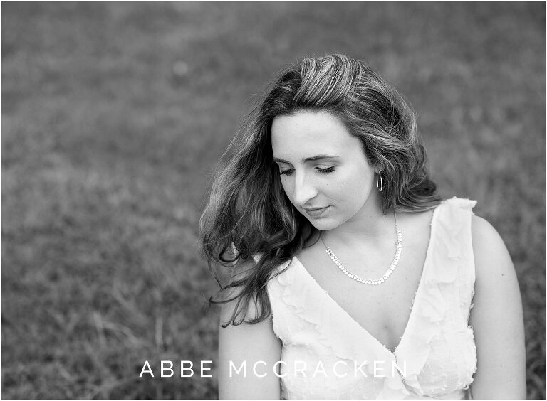 black and white senior portrait, hair blowing in the wind
