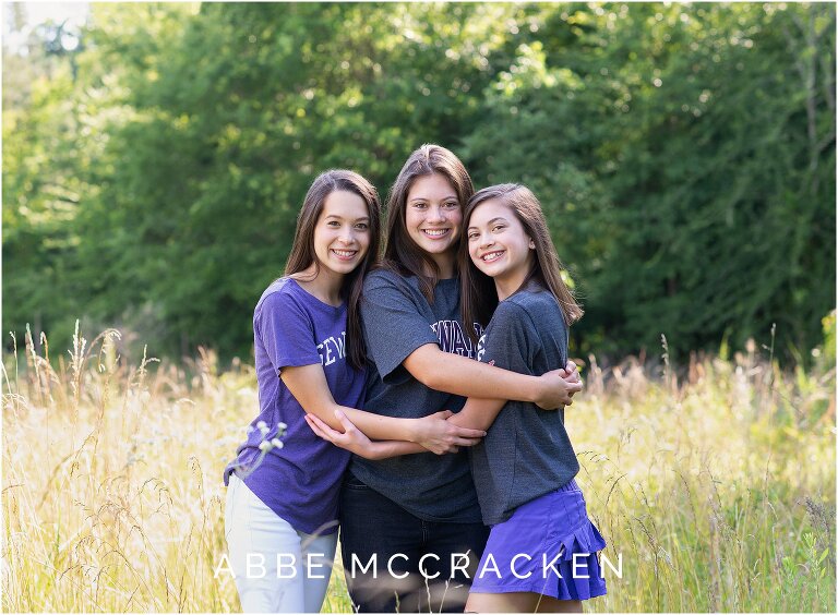 Senior portrait with sibling sisters all wearing Sewanee shirts