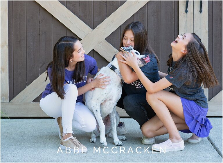 Candid image of sibling girls with their dog