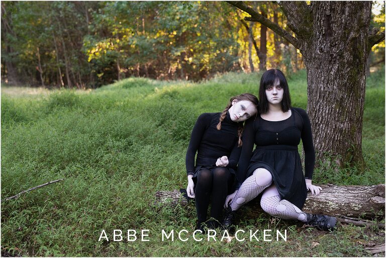 Halloween picture of teenage daughters dressed as ghosts in a forest as the sun sets