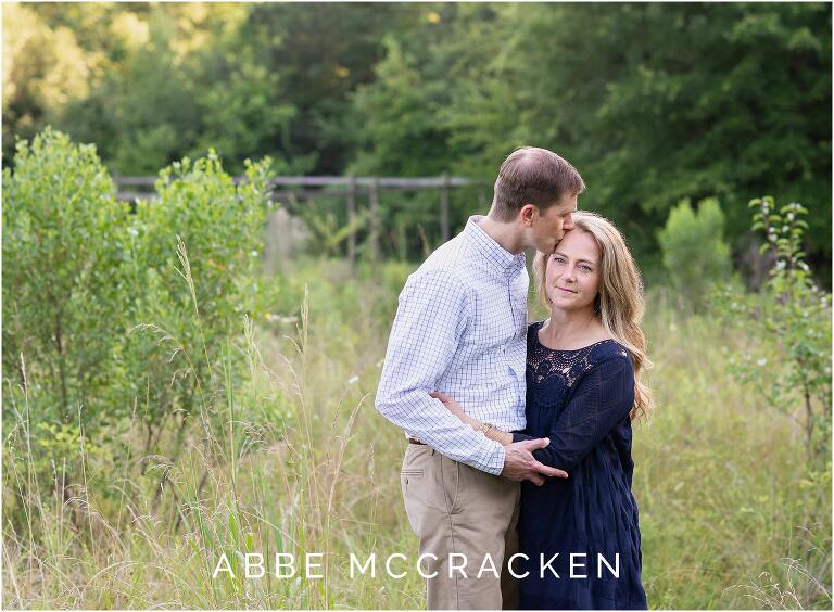 peaceful, reflective image of a husband kissing his wife's forward during a summer family photo session