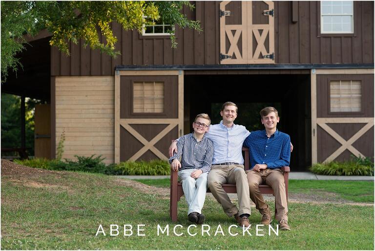 Father and sons sitting near the barn at Marvin Efird Park