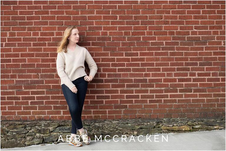 Senior portrait on a red brick wall in Blowing Rock, NC