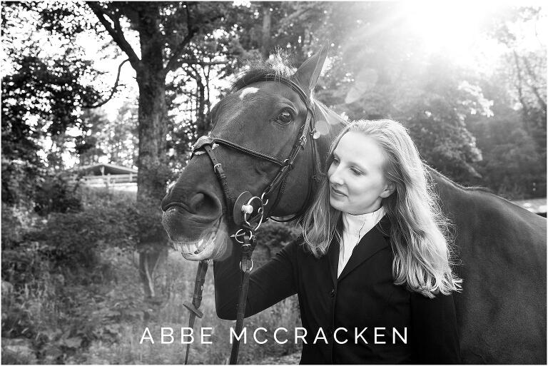 senior portrait of a girl with her horse, horse is smiling and sun flare is illuminating the horse's smile