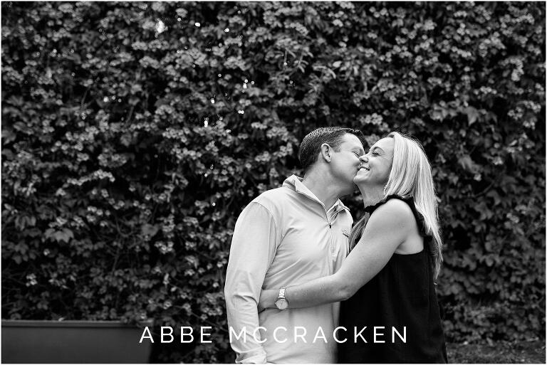 black and white image of husband kissing his wife's cheek in Uptown Charlotte