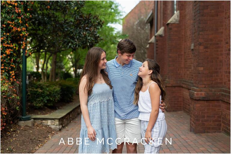 high school senior brother talking to his younger sisters
