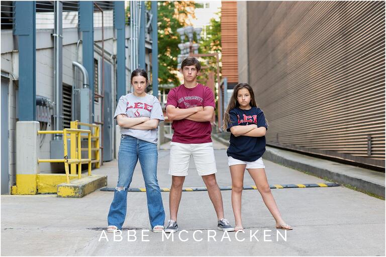 Siblings standing in an Uptown Charlotte alleyway wearing Lee University shirts.
