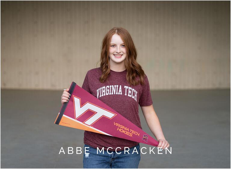 High school senior in Virginia Tech t-shirt, holding VT pennant