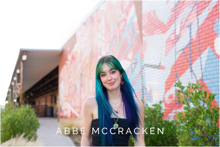 Senior portrait with colorful mural in background