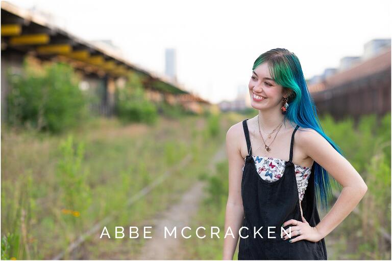 Candid portrait of a high school senior girl laughing at family off camera