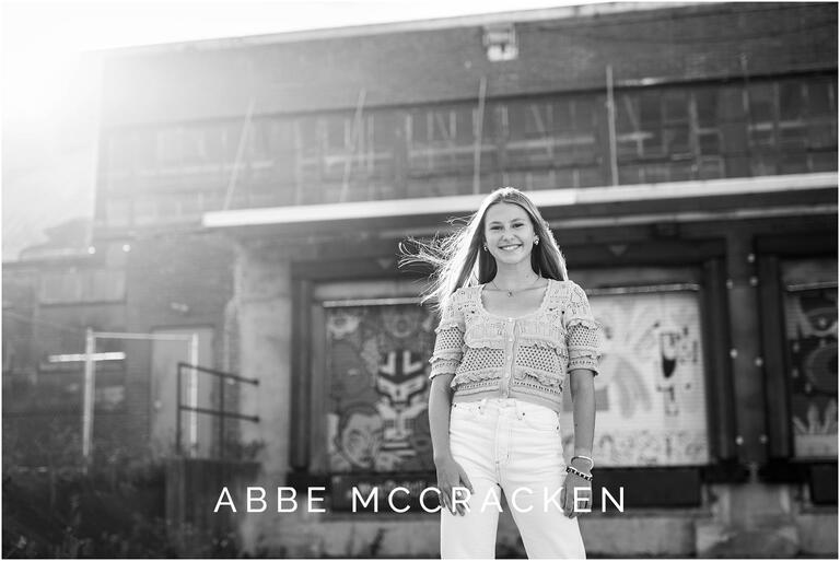 Black and white urban senior portrait with sun flare