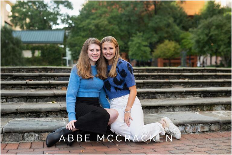 Teenage sisters sitting on steps at The Green, Charlotte NC