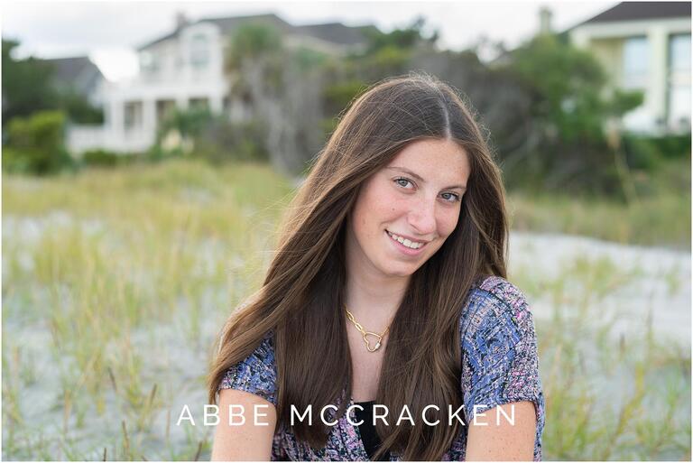 Headshot of a senior girl on sitting in front of the dunes on Isle of Palms, South Carolina