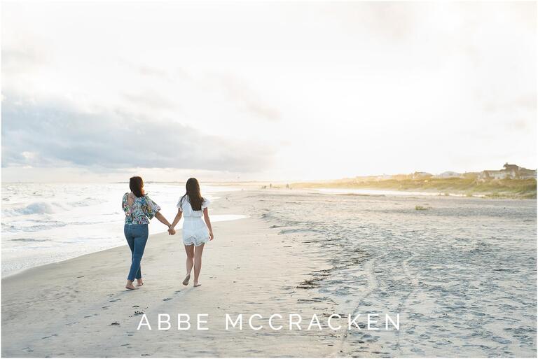 Sunset picture of a mother and high school senior daughter walking on the beach at Isle of Palms, SC