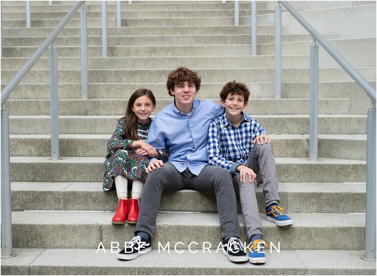 Urban portrait of siblings sitting together on city steps
