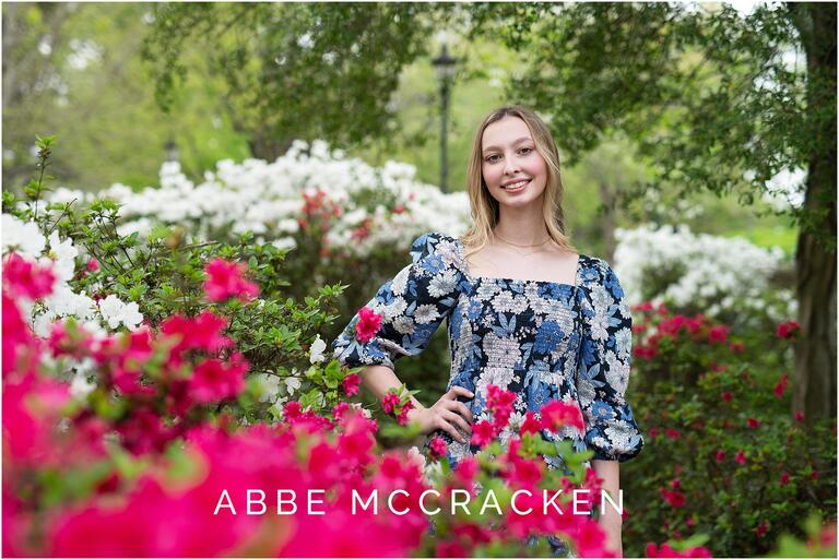 Girl in a blue floral dress standing amongst pink and white azaleas in Charlotte, NC