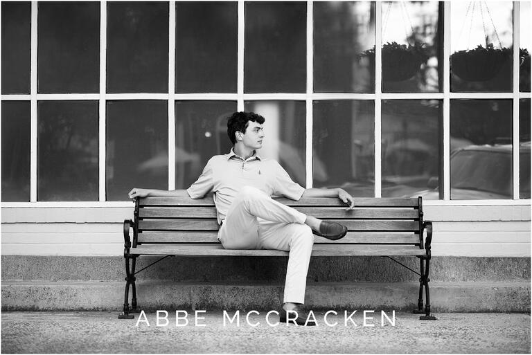 Black and white candid of a high school senior sitting on a bench in Matthews, NC