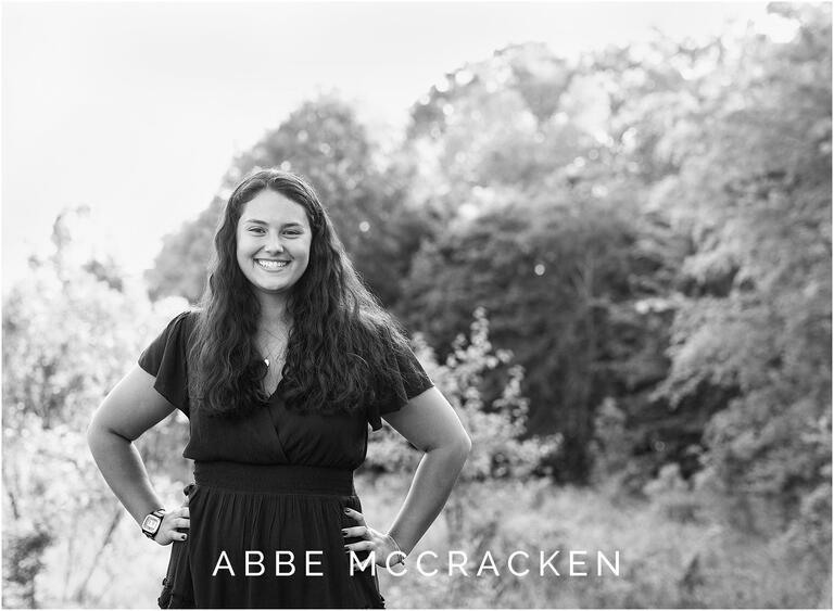 Black and white senior portrait of confident graduate