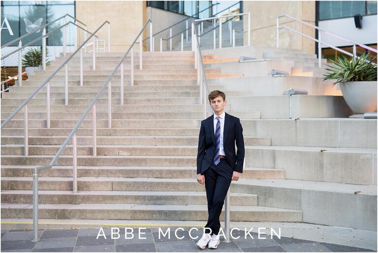 Senior portrait of boy in a suit and tie outside Mint Museum