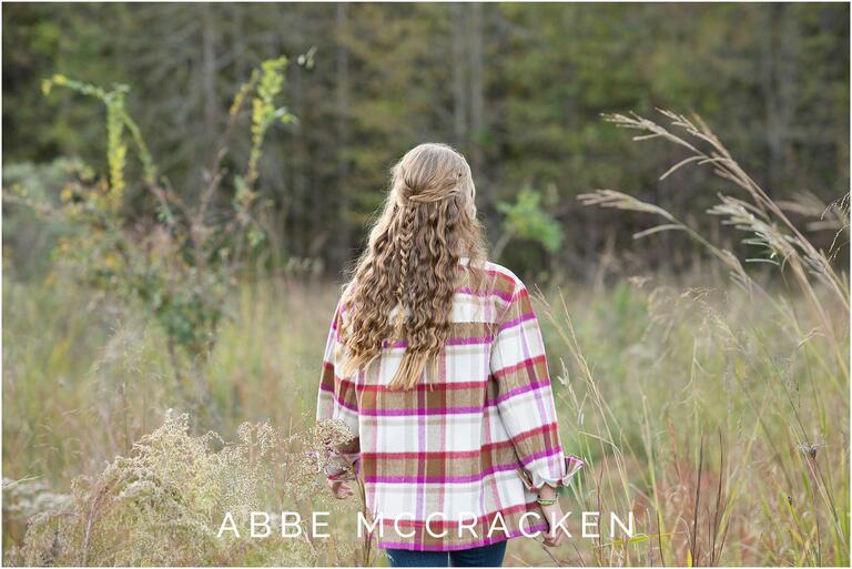 High school senior with long blonde hair and a braid down the back, plaid jacket