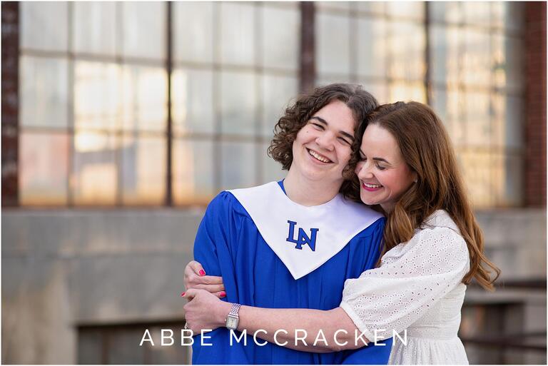 Senior guy in Lake Norman High School blue gown, mom hugging him